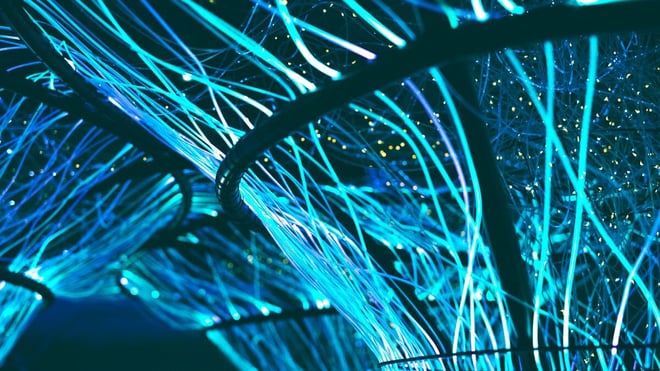 Bright blue neon strands curving through a dark space.
